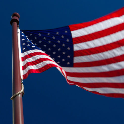 american flag and city buildings economic future construction costs